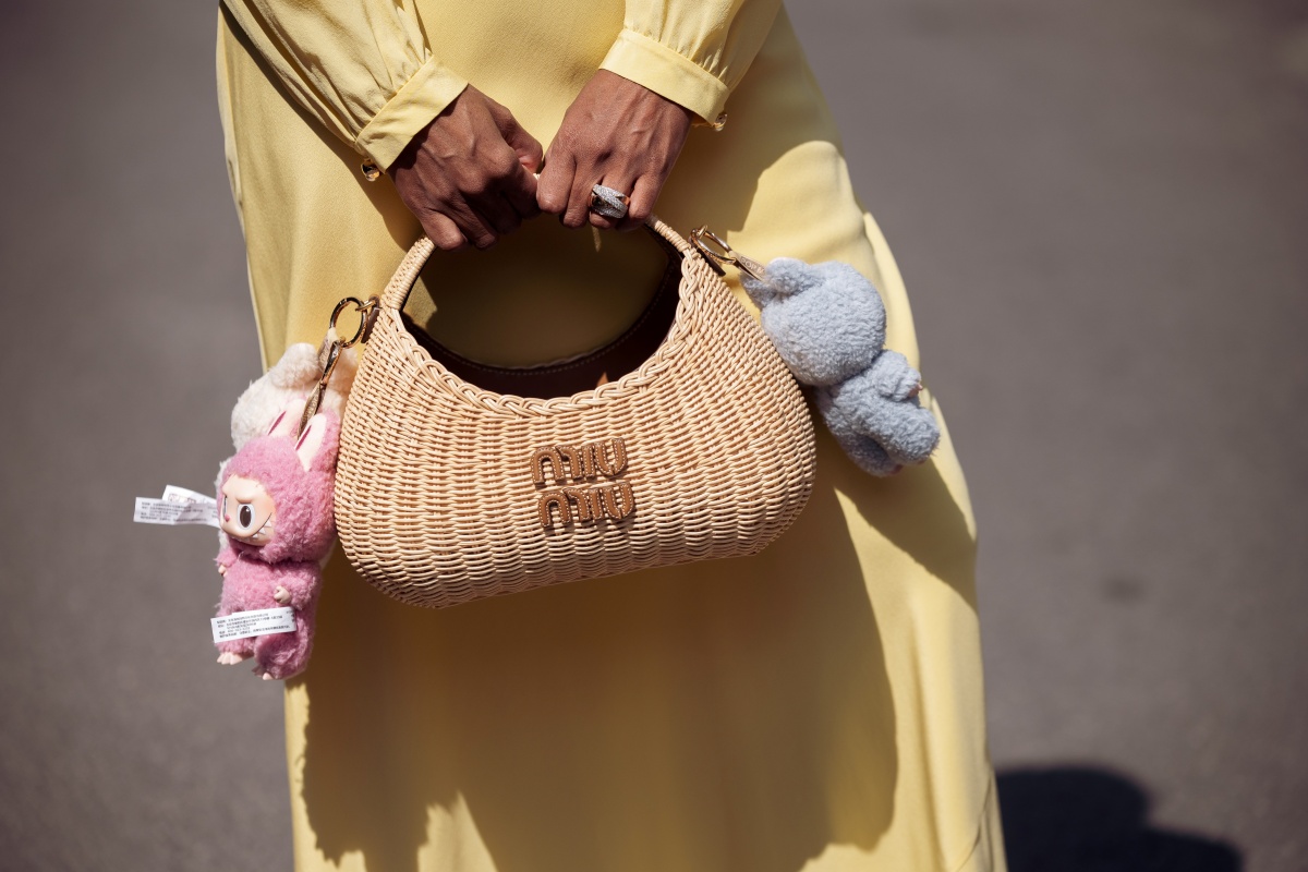 Alexander usa um look Miu Miu completo, feito com um vestido longo de verão amarelo-manteiga e uma bolsa de palha Miu Miu com pingentes Labubu durante o quinto dia do 78º Festival de Cinema de Cannes