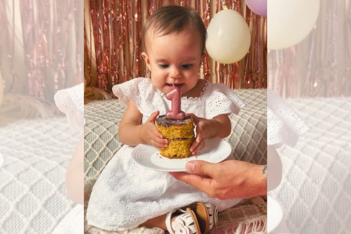 Foto colorida de bebê com um bolo 
