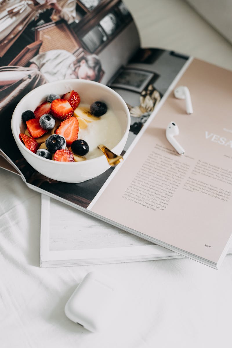 Bowl com iogurte e frutas em cima de revista - Metrópoles