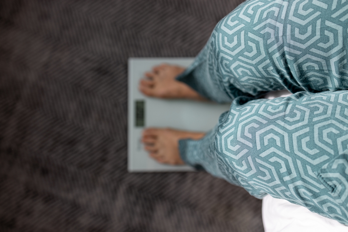Pernas de mulher sentada sobre uma balança - Metrópoles