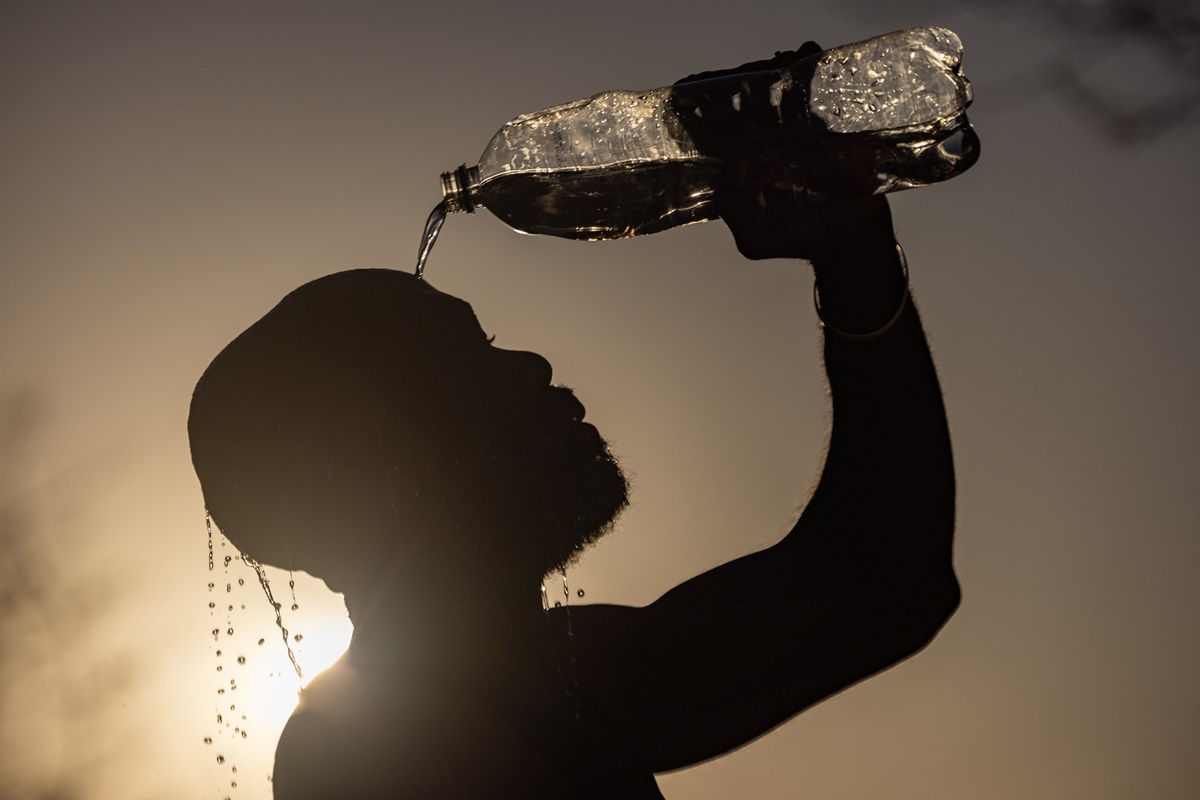 Imagem colorida de homem se refrescando com água em meio a seca na África do Sul - Metrópoles 