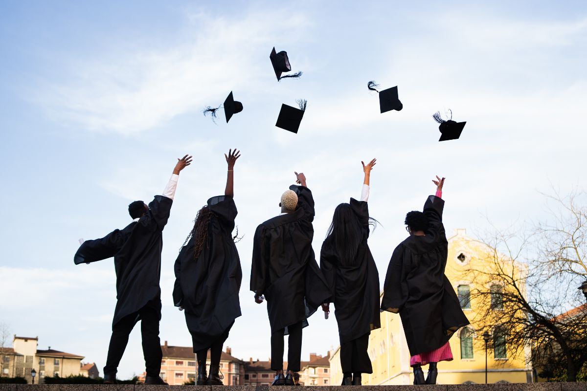foto de jovens de costa em formatura, jogando chapeu