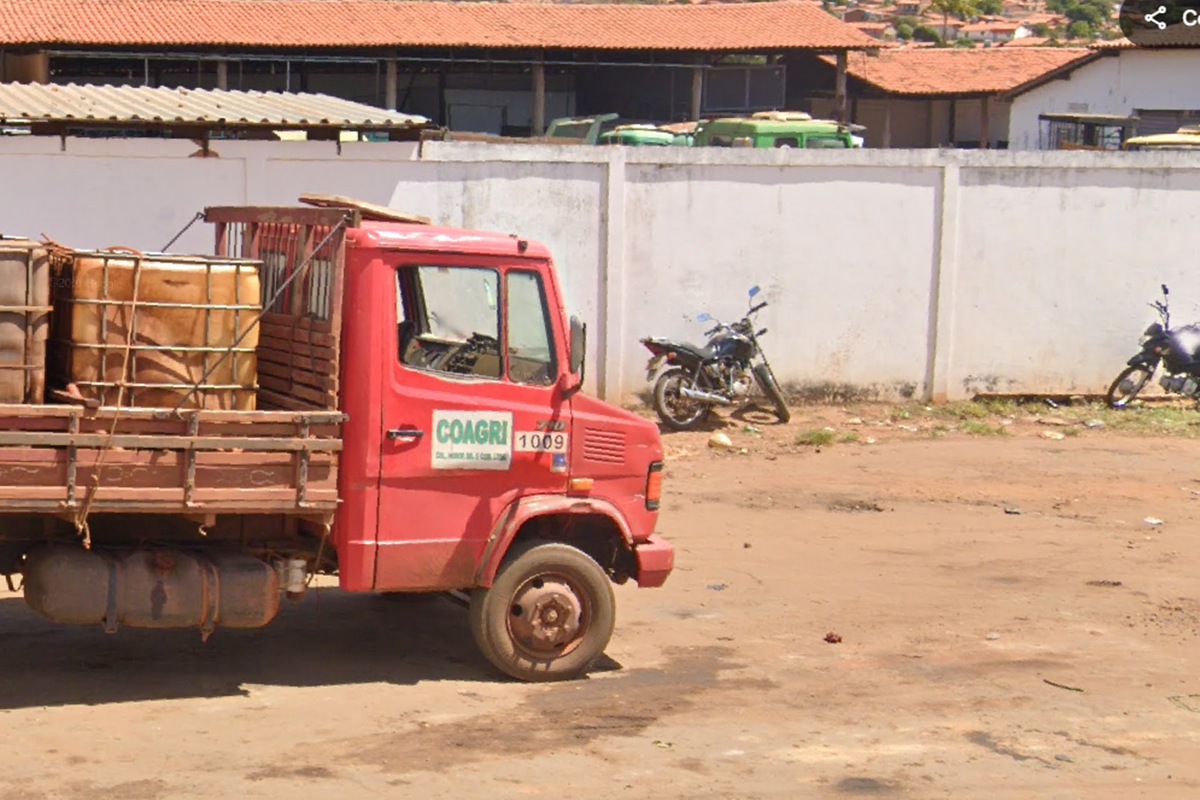 Caminhão com a logo da agropecuária Coagri estacionado em frente a lote com placa da Vigas Engenharia
