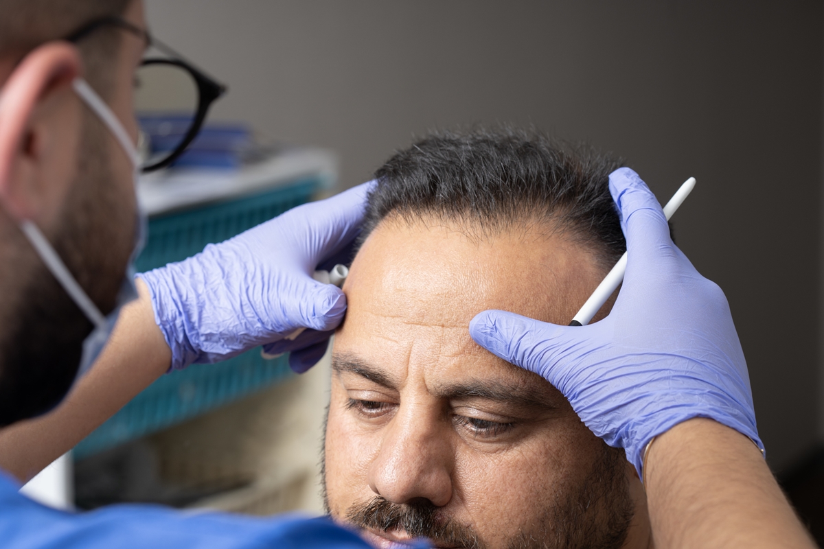 Médico examinando testa de paciente - Metrópoles