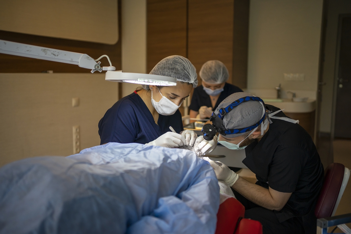 Médicos realizando transplante capilar em paciente - Metrópoles