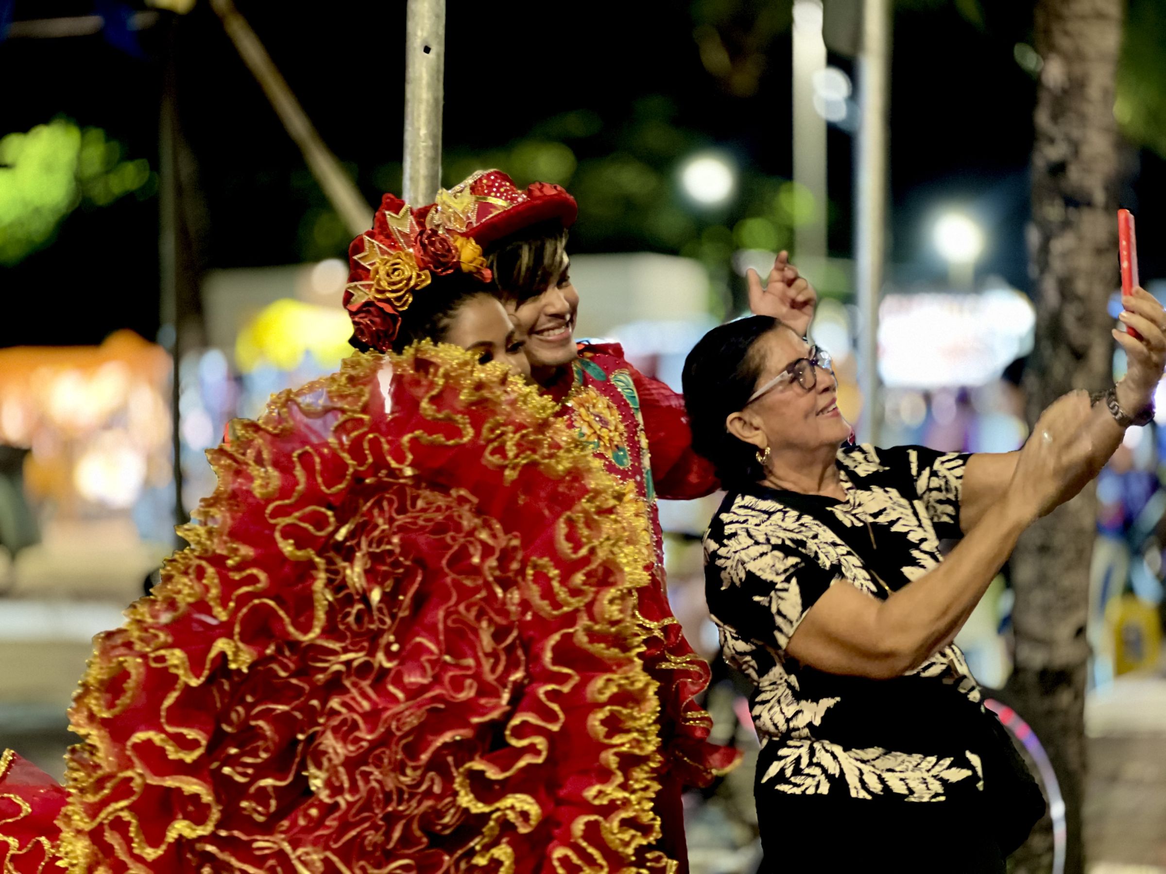 Fotografia colorida mostrando mulher tirando foto com dançarinos de quadrilha junina-Metrópoles