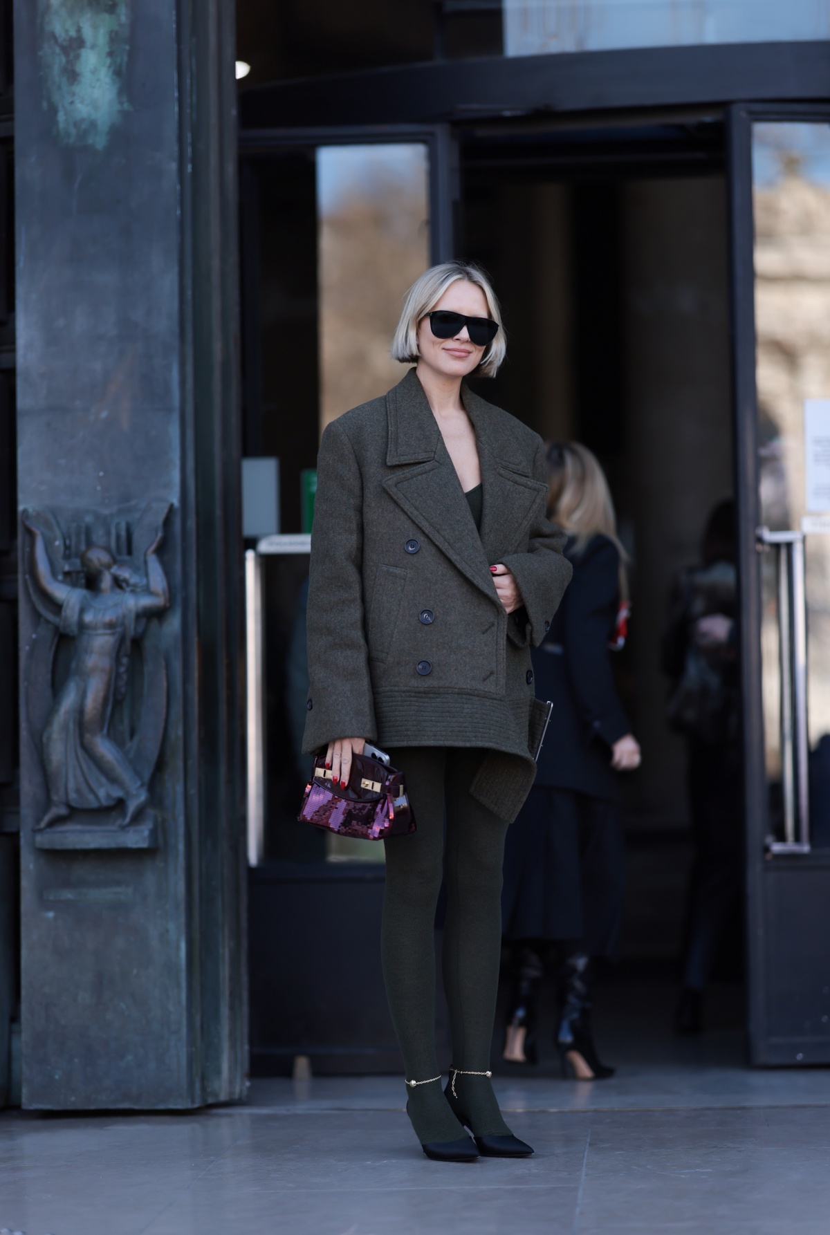 A imagem mostra uma mulher fotografada enquanto anda na rua