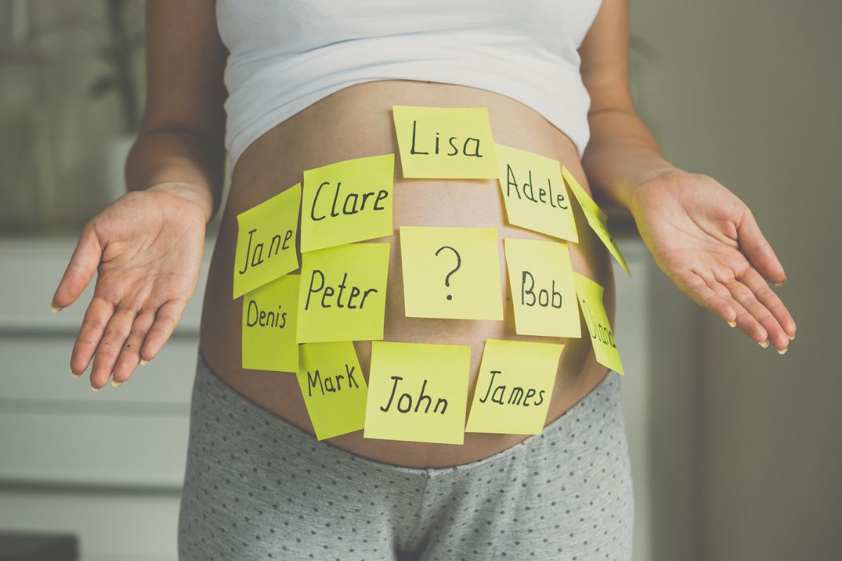 Barriga de grávida com post its amarelos com nomes escritos