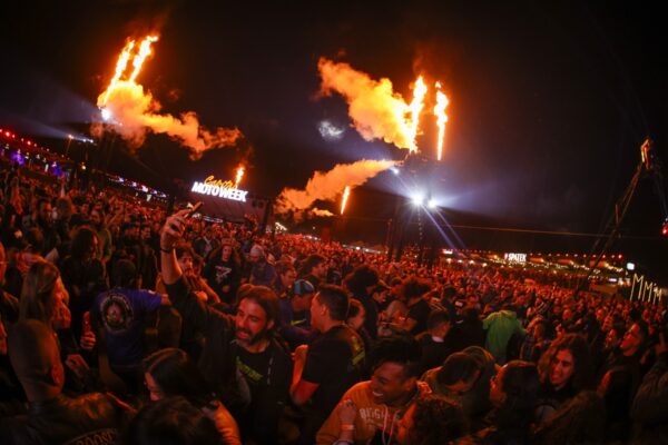 publico de um show lotado varias pessoas olhando para as chamas sendo lançadas do palco