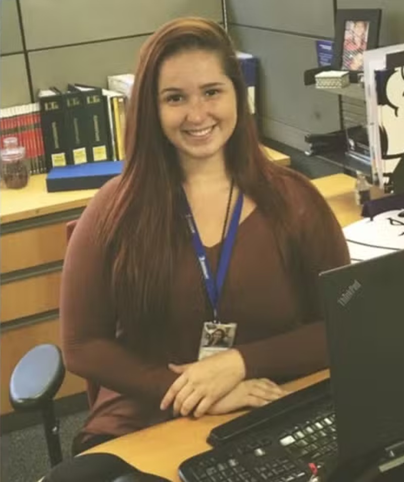 Mulher de cabelo longo e crachá em escritório 