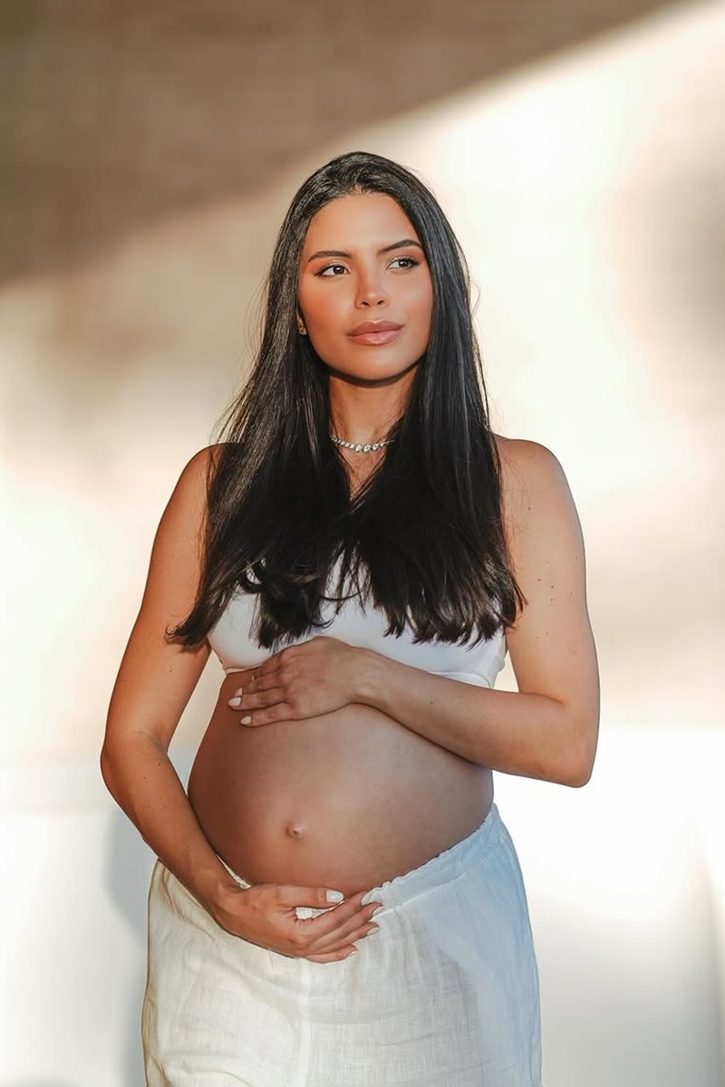 Foto colorida de mulher grávida posando para fotos - Metrópoles