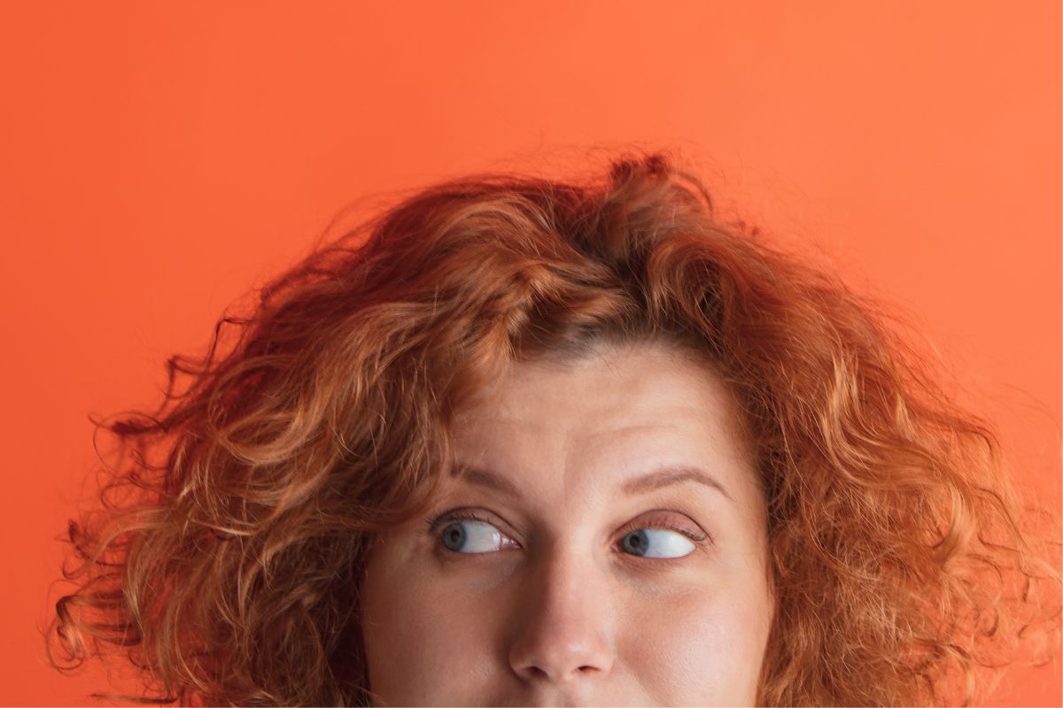 Farbfoto einer Frau, die beim Sprechen wegschaut