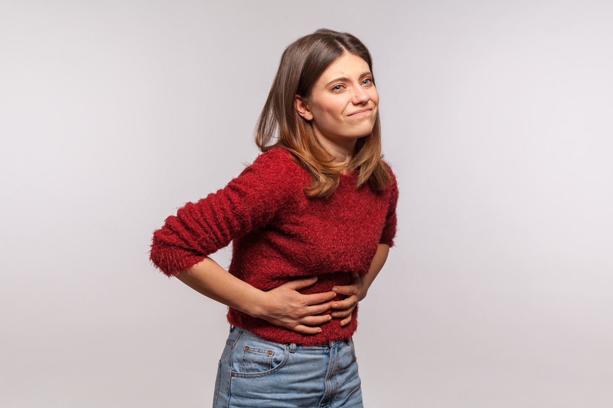 Foto colorida de mulher com as mãos na barriga - Metrópoles
