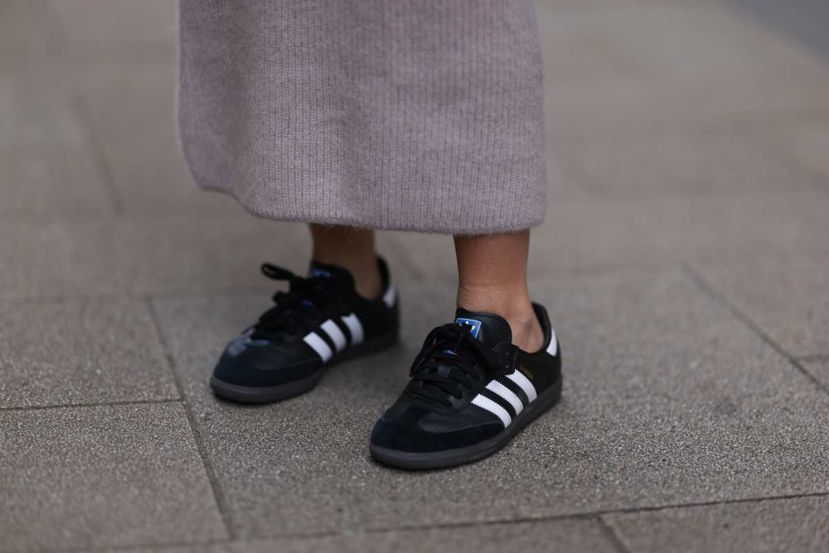 A imagem mostra uma pessoas posando com o Adidas Samba amarelo