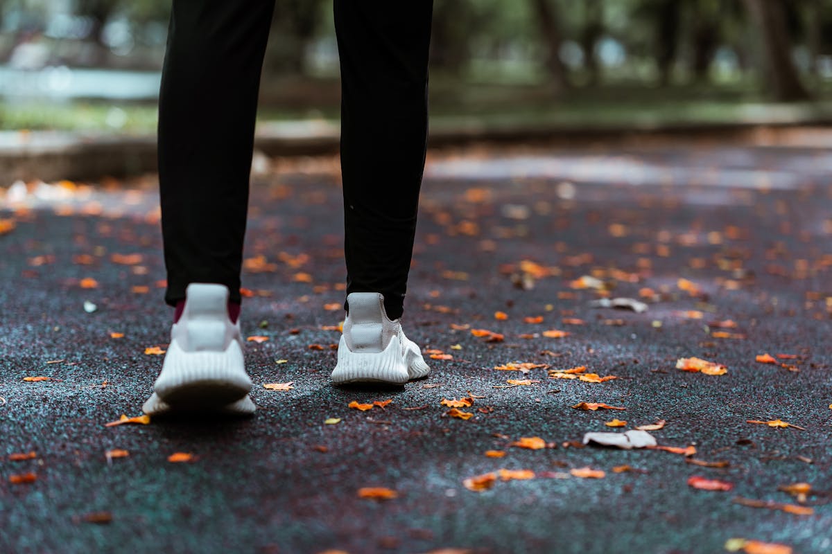 Pernas de mulher com tênis e calça legging andando em calçada - Metrópoles