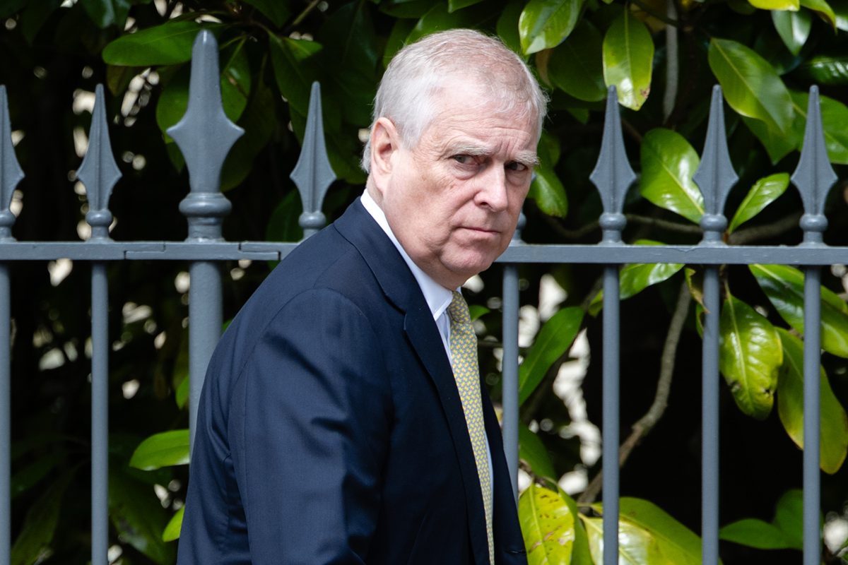 Foto colorida de homem de terno caminhando próximo a portão - Metrópoles