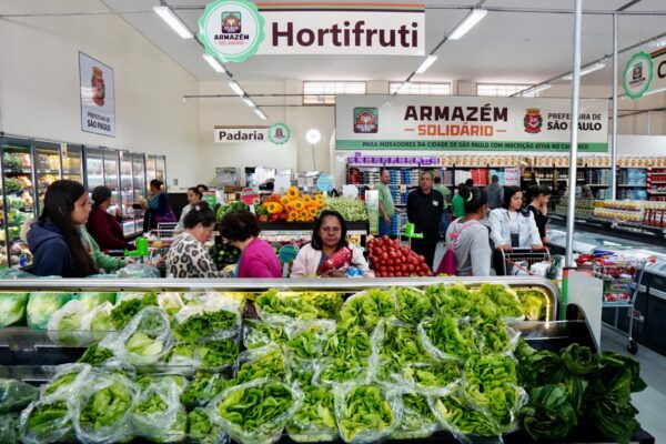 foto de uma mulher em um supermercado escolhendo verduras