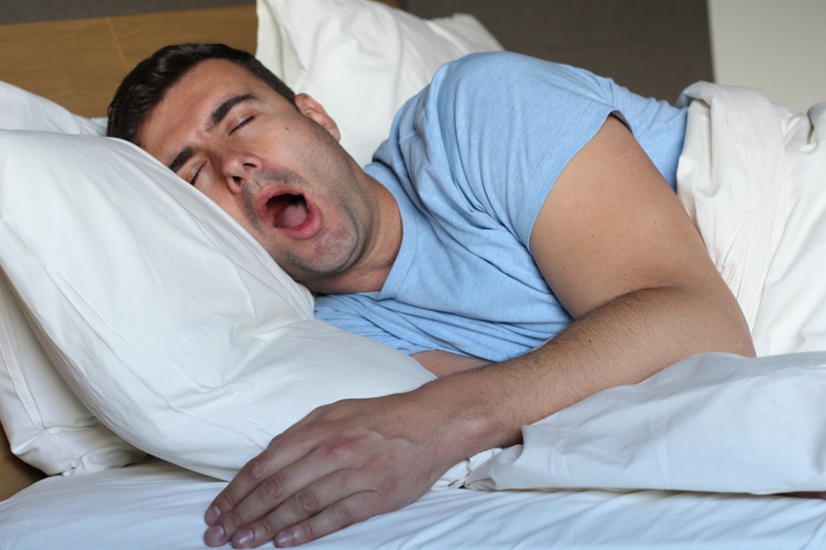 Foto colorida de homem roncando enquanto dorme - Metrópoles