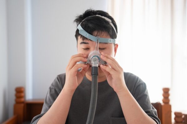 Foto colorida de homem com o aparelho CPAP, que trata a apneia do sono - Metrópoles