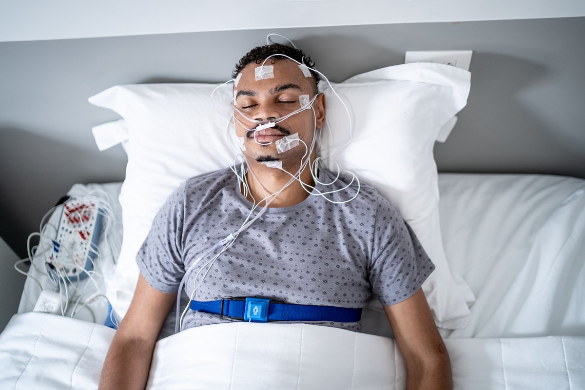 Foto colorida de homem fazendo uma polissonografia - Metrópoles