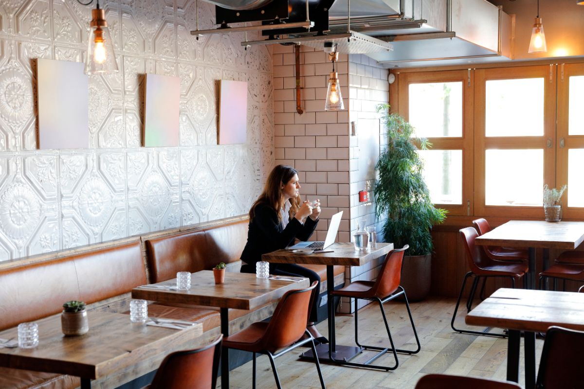 Farbfoto einer Frau, die alleine in einem Restaurant isst