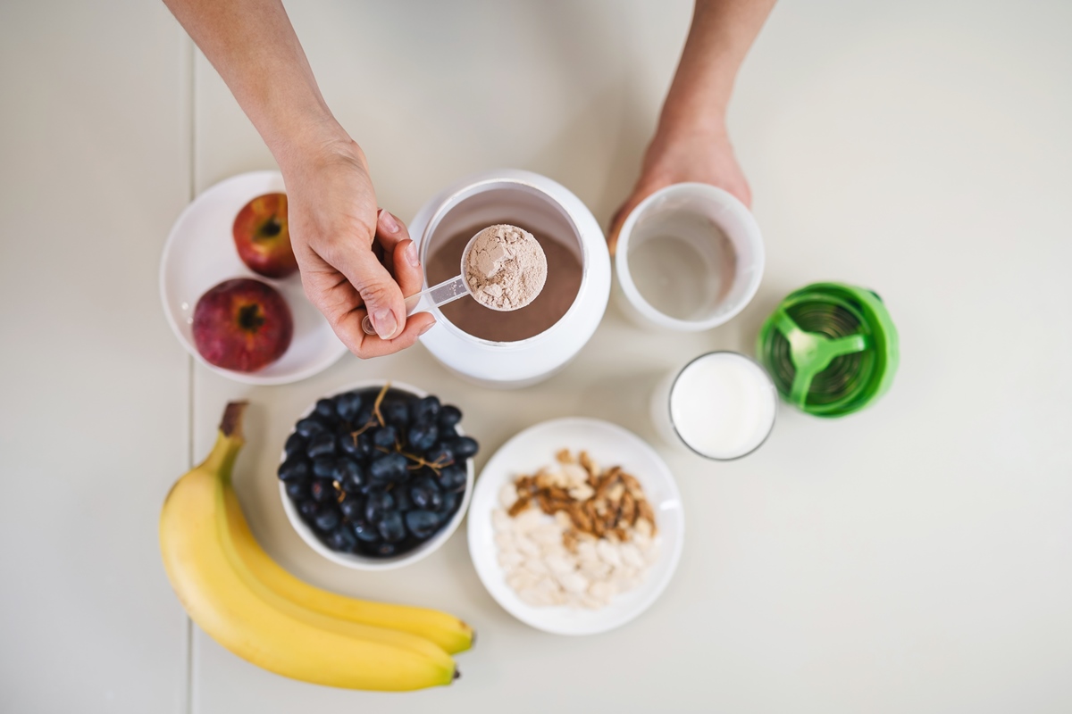 Imagem mostra suplemento whey protein com vários potes de frutas - Metrópoles