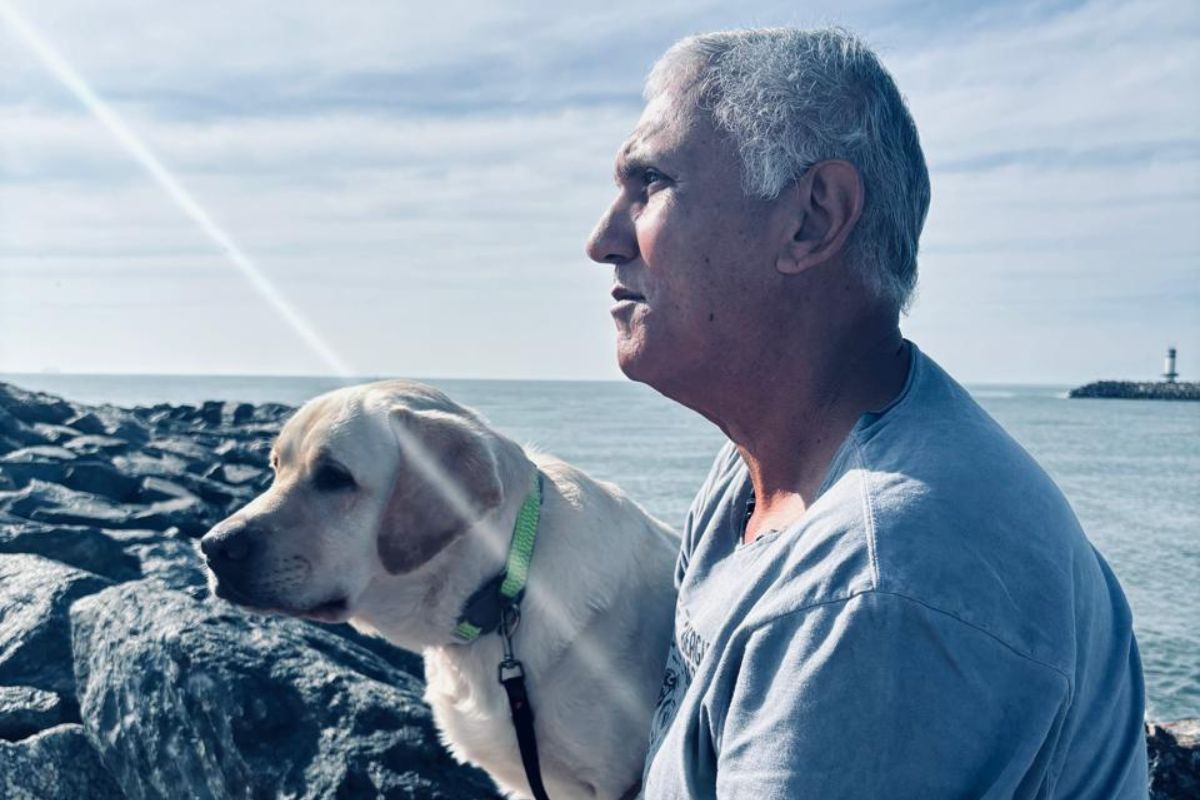 Imagem colorida de homem ao lado de cachorro