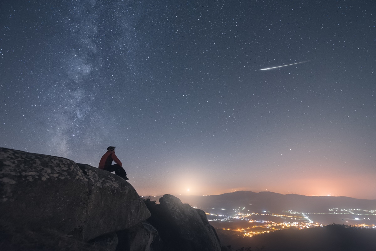 Imagem colorida de pessoa observando chuva de meteoros - Metrópoles