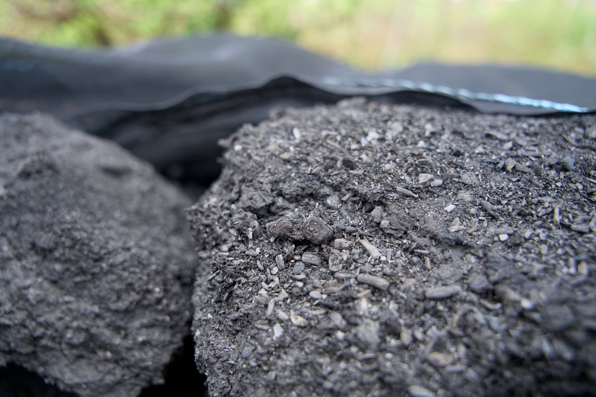 Foto colorida de terra preta dentro de um saco preto - Metrópoles.