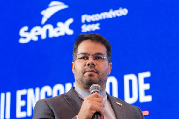 Homem latino dando uma palestra de terno