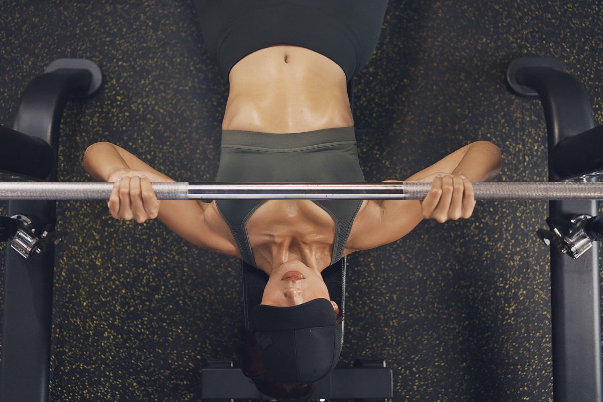 foto colorida mulher realizando treino de peito na academia