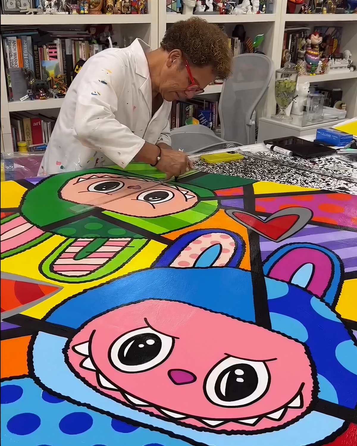 A imagem mostra o pintor Romero Britto pintando Labubus em um quadro - Metrópoles