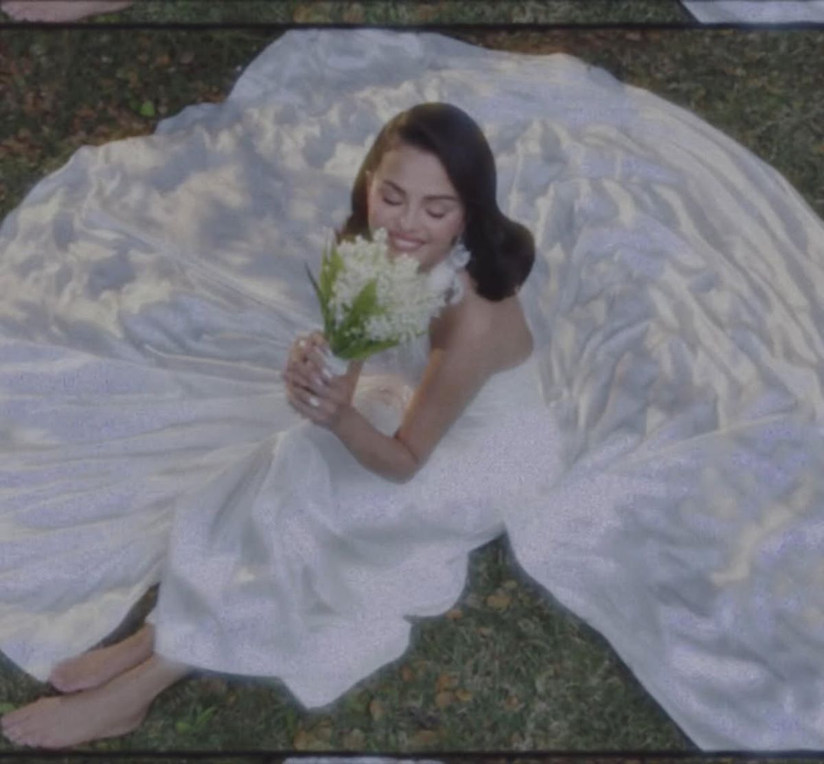 Imagem colorida de Selena Gomez sentada com vestido de noiva 