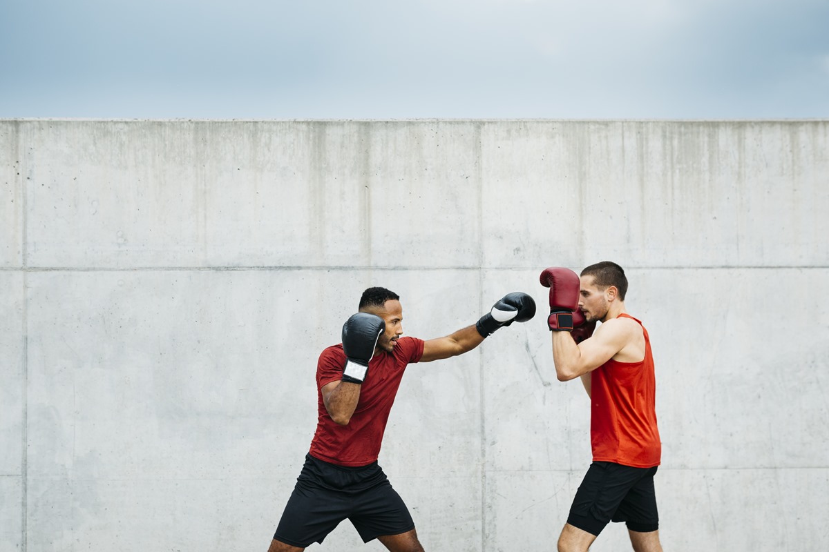 Imagem colorida mostra lutadores de boxe lutando - Metrópoles
