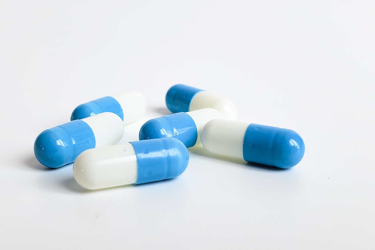 cápsulas médicas antibióticos branco azul sobre fundo branco, Metrópoles