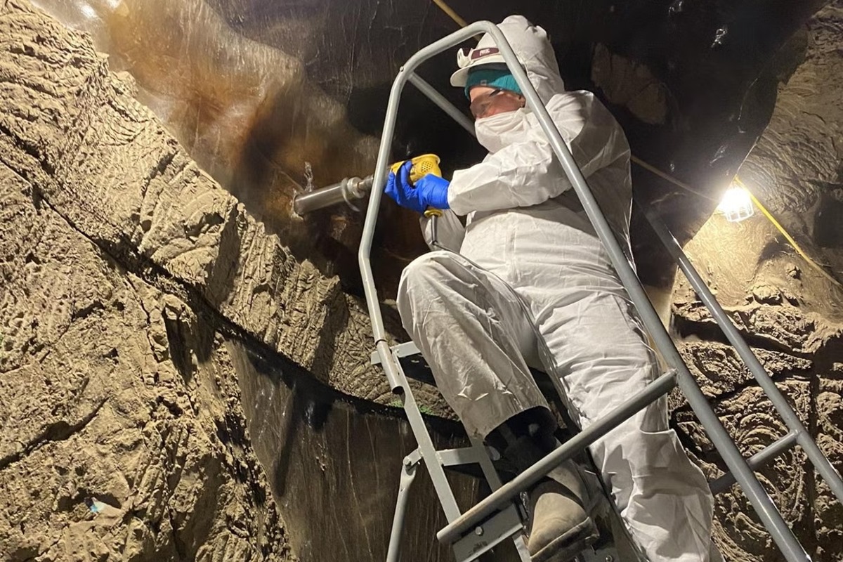 Imagem colorida mostra pesquisador colhendo amostras em permafrost em túnel no Alasca (EUA) - Metrópoles