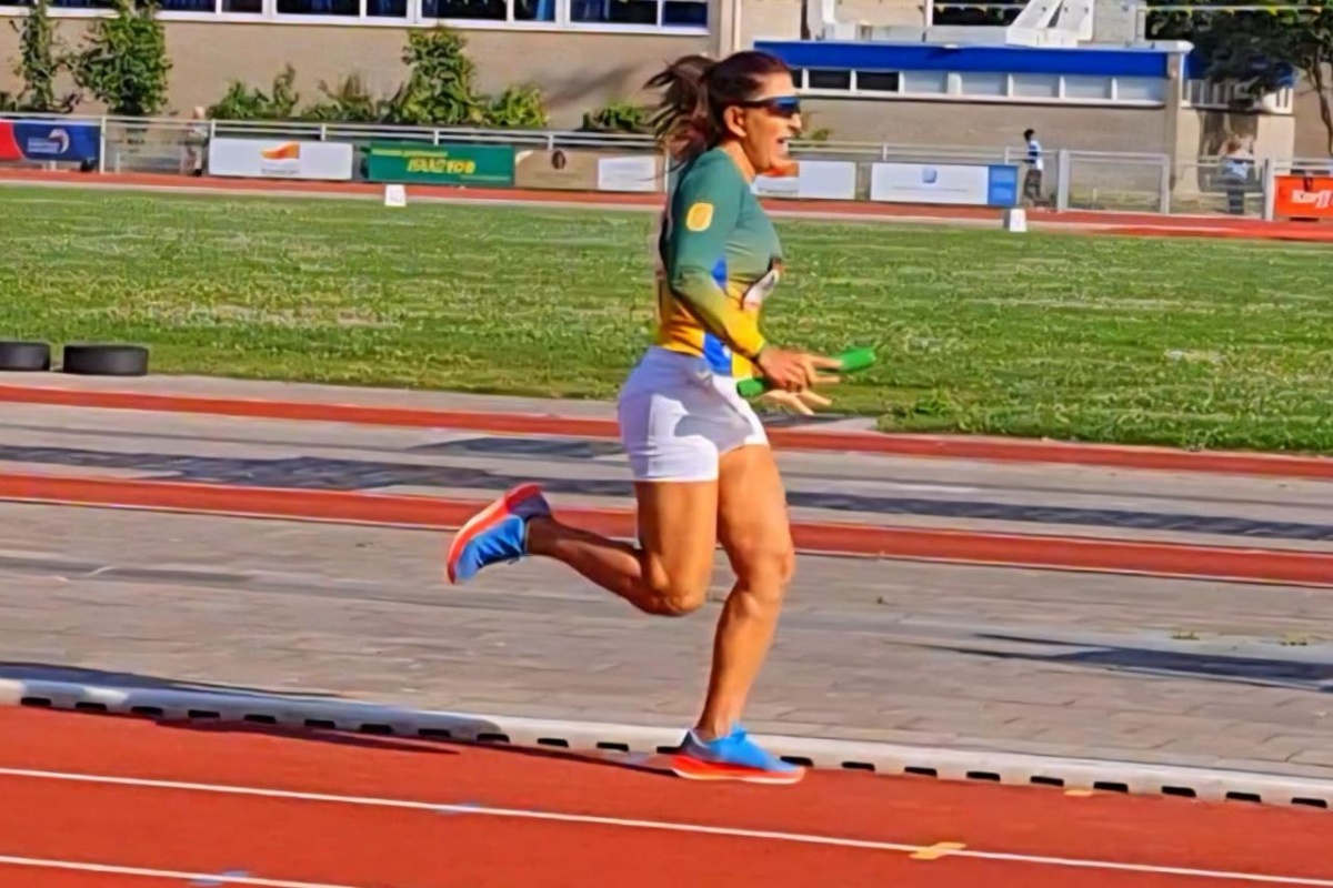 Foto colorida de mulher com blusa, short e tênis em posição de corrida - Metrópoles.