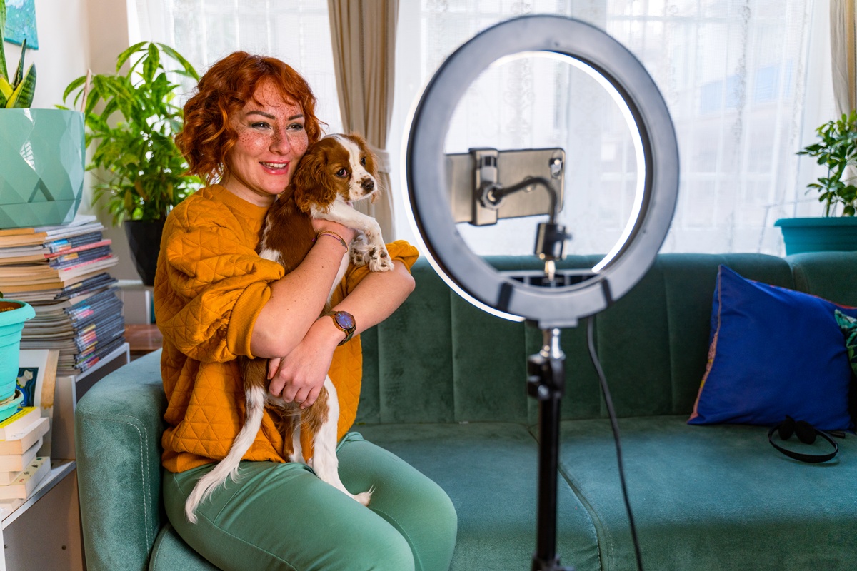 Influenciadora animada gravando vídeo com cachorro