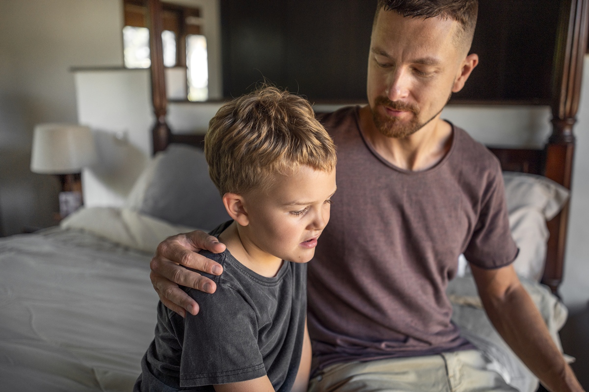 Foto colorida de pai acolhendo filho em processo de luto - Luto na infância: como orientar e acolher a criança após uma perda - Metrópoles