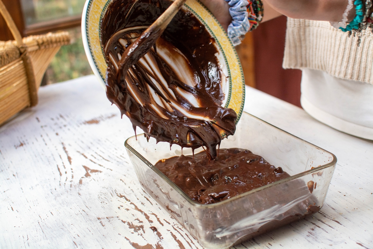 receita palha italiana de travessa - pessoa colocando brigadeiro em travessa