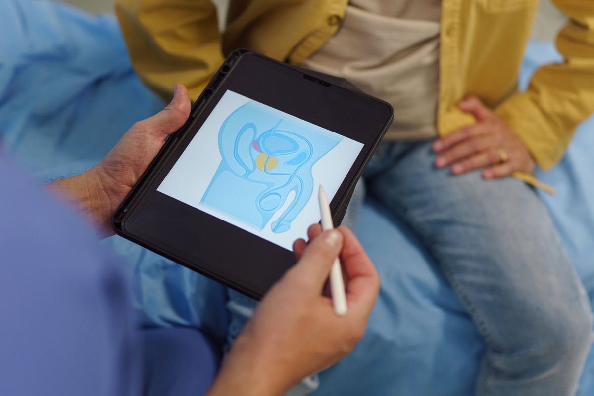 Foto de médico mostrando ilustração de próstata para paciente - Metrópoles